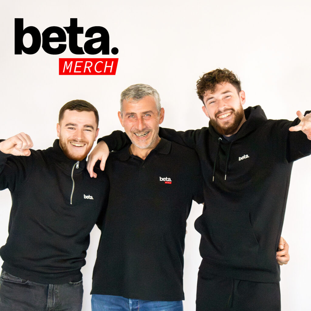 Photo de l’équipe Beta Merch : trois membres posant ensemble en polo noir Beta Merch