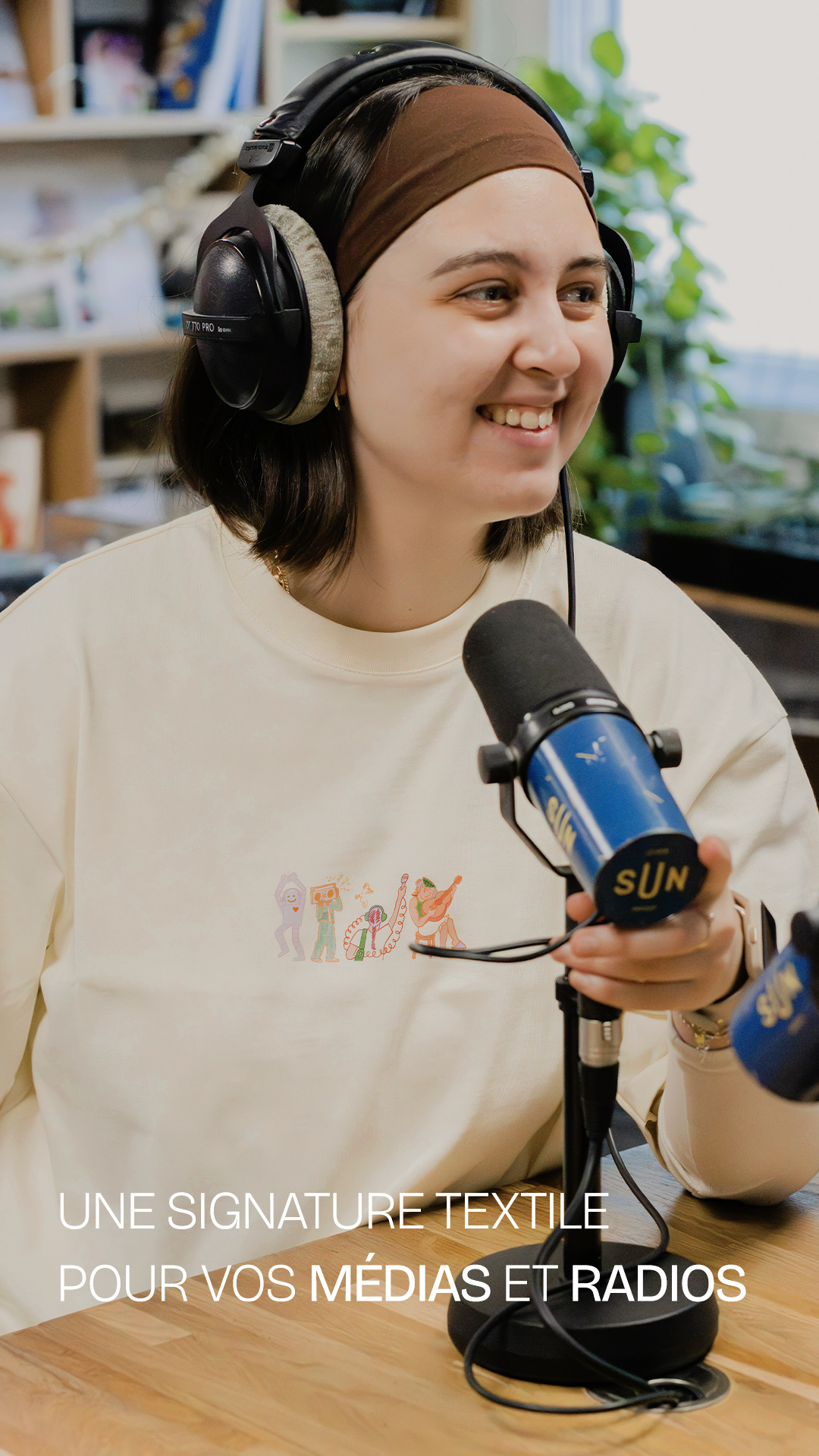 Animatrice en studio radio avec micro, portant un t-shirt merch personnalisé Beta Merch, solution textile sur mesure pour radios, médias et podcasts.